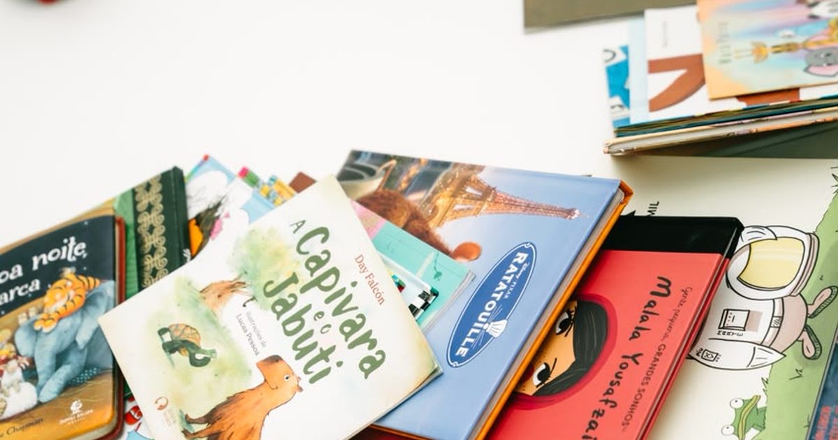 Livros infantis coloridos espalhados no chão